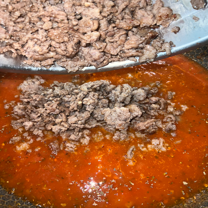 The meat being added to the sauce