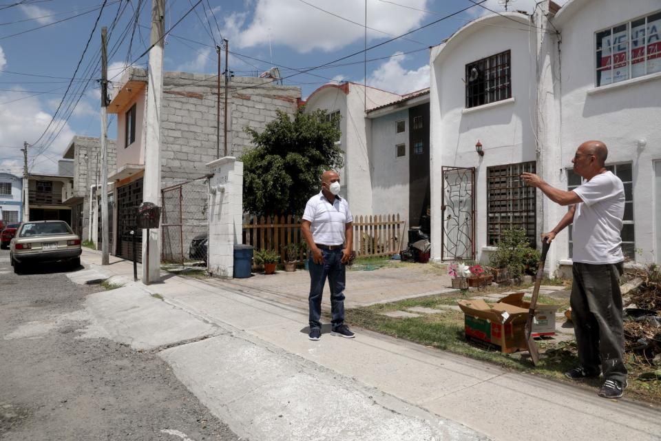 Fernando Trejo Reyes talks with a neighbor in Querétaro. "I never knew what unemployment was," he says.