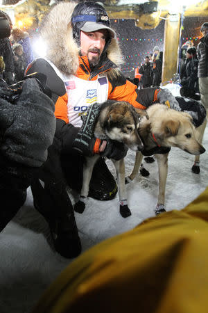 Pete Kaiser of of Bethel, Alaska holds his lead dogs Lucy and Morrow after winning the Iditarod Trail Sled Dog Race in Nome, Alaska, U.S. March 13, 2019. REUTERS/Diana Haecker/Nome Nugget