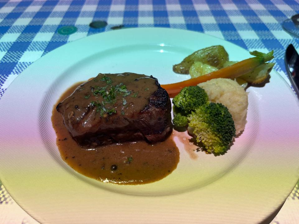 White plate with steak and vegetables at Le Petit Chef