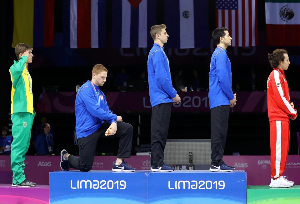 LIMA, PERU - AUGUST 09: Gold medalist Race Imboden of United States  takes a knee during the National Anthem Ceremony in the podium of Fencing Men's Foil Team Gold Medal Match Match on Day 14 of Lima 2019 Pan American Games at Fencing Pavilion of Lima Convention Center on August 09, 2019 in Lima, Peru. (Photo by Leonardo Fernandez/Getty Images) ORG XMIT: 775311501 ORIG FILE ID: 1167100210