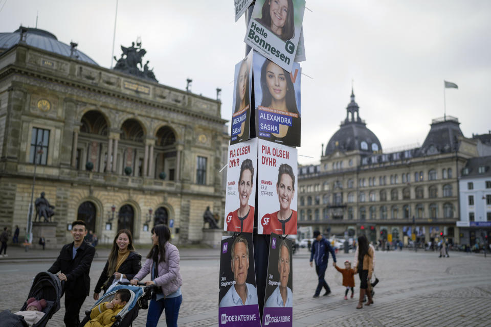 People pass by election campaign posters in Copenhagen, Denmark, Sunday, Oct. 30, 2022, ahead of the general election on November 1, 2022. (AP Photo/Sergei Grits)