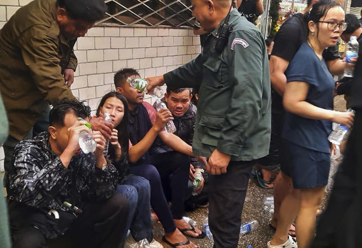 Sur cette photo fournie par Cambodia's Fresh News, les victimes d'un incendie reçoivent de l'eau des policiers près d'un poste frontière international entre le Cambodge et la Thaïlande à Poipet, à l'ouest de Phnom Penh, au Cambodge, le jeudi 29 décembre 2022. / Crédit : Fresh News via PA