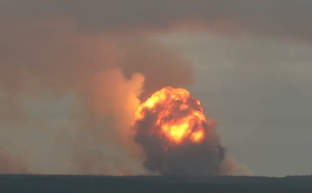 A view shows flame and smoke rising from the site of blasts at an ammunition depot in Krasnoyarsk region