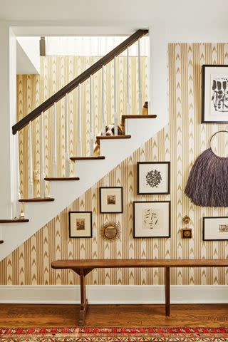 <p>Hector Manuel Sanchez</p> The designer chose all black frames to make the entry's gallery wall feel cohesive.