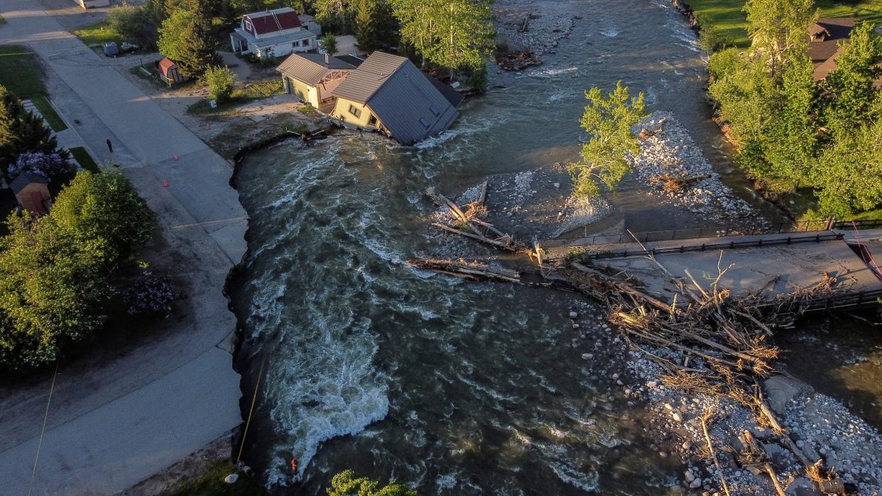 house falls into flooded river with eroded road