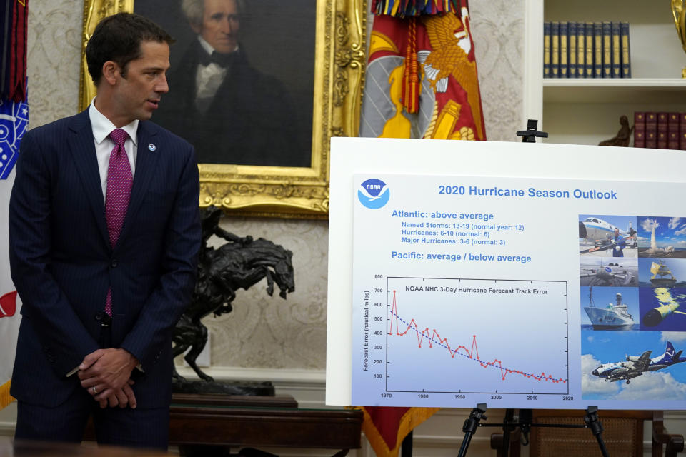 FILE - In this Thursday, May 28, 2020 file photo, Neil Jacobs, assistant Secretary of Commerce for Environmental Observation and Prediction, stands next to a chart during a briefing with President Donald Trump on the 2020 hurricane season in the Oval Office of the White House in Washington. A report from the National Academy of Public Administration released on Monday, June 15, 2020 says that NOAA’s acting chief Jacobs and its then-communications director, Julie Kay Roberts, twice breached the agency’s rules designed to protect scientists and their work from political interference, putting out a press statement that “did not follow NOAA’s normal proves and appear to be the result of strong external pressure.” (AP Photo/Evan Vucci)