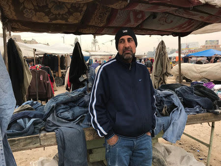 FILE PHOTO - Moayad stands in front of the market stall where he sells second-hand jeans in al-Nabi market in the east Mosul, Iraq, January 11, 2018. REUTERS/Raya Jalabi