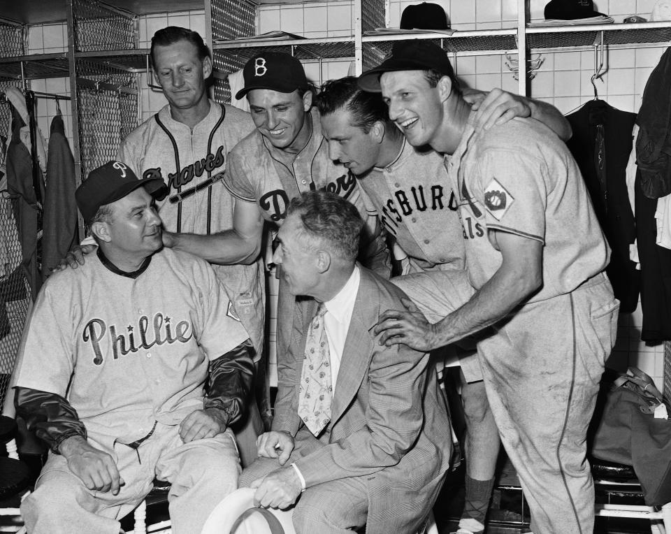 Four national league stars, who punded out home runs to lead their club to an 8 to 3 win over the American league yesterday, are all smiles as they listen to manager Eddie Sawyer (seated left) and President Ford Frick of the league discuss the victory on July 11, 1951 in Detroit. The home run hitters standing are (left to right) Bob Elliott of the Braves; Gil Hodges of the Dodgers; Ralph Kiner of the Pirates and Stan Musial of the Cardinals.