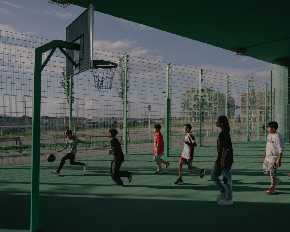 Basketball and soccer courts, climbing facilities and playgrounds were built under the drawbridge in the "Am Seebogen" neighborhood in Vienna, Austria. Kids are seen playing together on Sept. 26, 2022.<span class="copyright">Ingmar Björn Nolting for TIME</span>