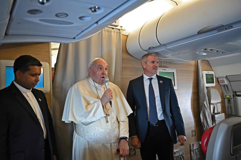 El Papa Francisco (C) saluda a los periodistas mientras está a bordo del avión de Roma a Manama durante su visita a Bahréin el 3 de noviembre de 2022.