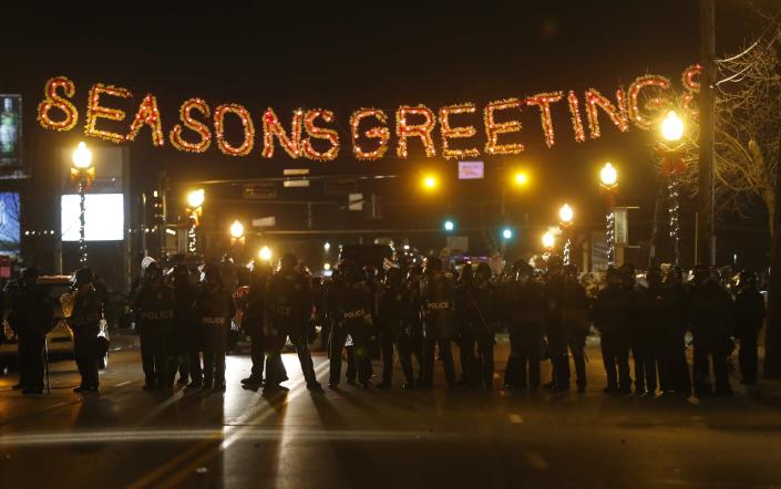 RNPS - REUTERS NEWS PICTURE SERVICE - PICTURES OF THE YEAR 2014 Police form a line in the street under a holiday sign after a grand jury returned no indictment in the shooting of Michael Brown in Ferguson, Missouri in this November 24, 2014 file photo. REUTERS/Jim Young/Files (UNITED STATES - Tags: CRIME LAW CIVIL UNREST TPX IMAGES OF THE DAY)