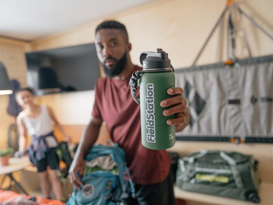 Someone holding a water bottle up to the camera