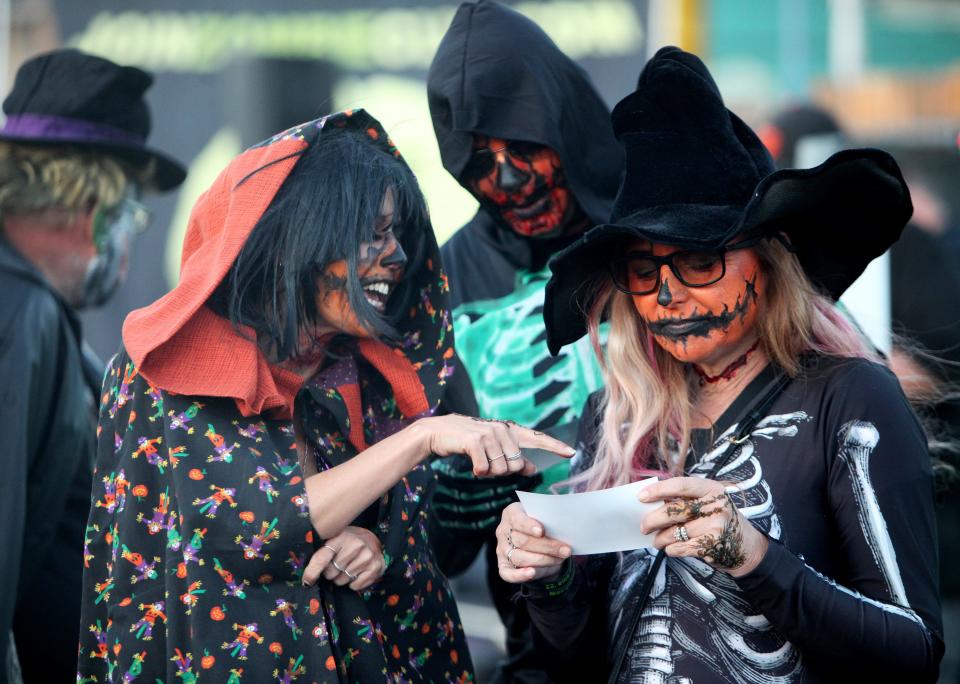 Jennifer Kiggins, of Lodi, left, Pete and Christine Burry, also of Lodi, check out their photograph from a photo booth at the Lodi Zombie Walk at IDOL Beer Works on Sunday, Oct. 23, 2022.