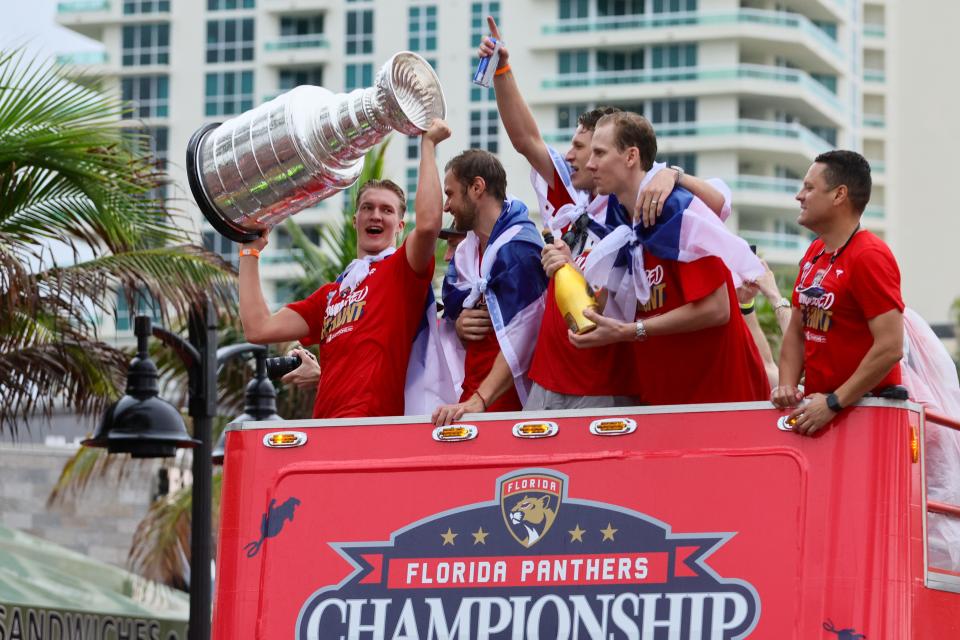 Florida Panthers center Anton Lundell (left) hoists the Stanley Cup during the team's victory parade and celebration.