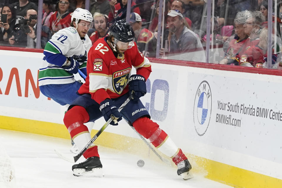 Florida Panthers center Kevin Stenlund (82) and Vancouver Canucks left wing Anthony Beauvillier (72) battle for the puck during the first period of an NHL hockey game, Saturday, Oct. 21, 2023, in Sunrise, Fla. (AP Photo/Wilfredo Lee)