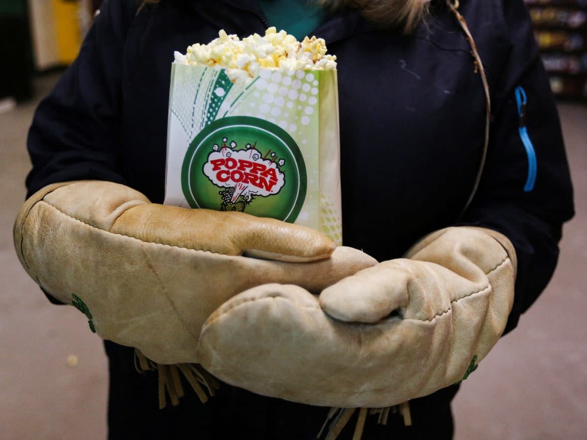 This moviegoer with mittens and popcorn came to the 1000 Islands Drive-In in Gananoque, Ont., earlier this week. Ontario movie theatres with auditoriums reopen Jan. 31. (Lars Hagberg/Reuters - image credit)