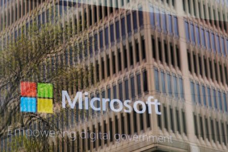 FILE PHOTO: An promotional video plays behind a window reflecting a nearby building at the Microsoft office in Cambridge, Massachusetts, U.S. on May 15, 2017.  To match Special Report USA-COURTSECRECY/HARASSMENT    REUTERS/Brian Snyder/File Photo