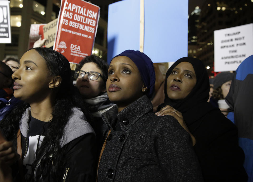 Ayla Ali (L-R), and her Somali refugee family members, cousin Ryan Adem and aunt Maryan Farah, listen to speakers at a rally for immigrants and refugees in Seattle, Washington on Jan. 29, 2017.