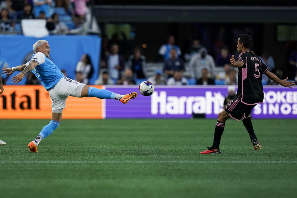 Charlotte FC forward Enzo Copetti, left, kicks the ball under pressure from Inter Miami midfielder Sergio Busquets (5) during the first half of an MLS soccer match, Saturday, Oct. 21, 2023, in Charlotte, N.C. (AP Photo/Erik Verduzco)