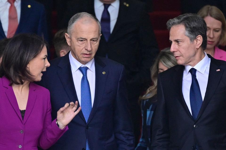 German Foreign Minister Annalena Baerbock, left, NATO Deputy Secretary General Mircea Geoana, center, and US Secretary of State Antony Blinken chat as they walk out of the building where the informal meeting of NATO Foreign Ministers on the conflict in Ukraine takes place, to pose for an official photo on May 15, 2022, in Berlin.