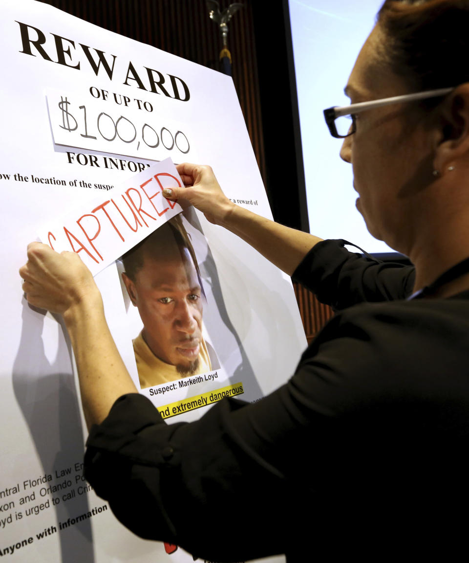 Orlando police public information officer Sgt. Wanda Miglio updates a wanted poster of Markeith Loyd before a news conference at Orlando Police Department to announce the capture of Loyd, Tuesday, Jan. 17, 2017, in Orlando, Fla. The suspect in the fatal shooting of an Orlando police officer was captured Tuesday night after eluding a massive manhunt for more than a week, authorities said. (Joe Burbank/Orlando Sentinel via AP)
