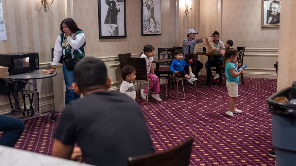 Children play and eat under pictures of President Theodore Roosevelt, after whom the hotel was named, and bandleader Guy Lombardo, on September 20, 2023. - Evelio Contreras/CNN