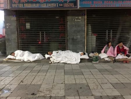 Tourists sleep on a street after an earthquake in Jiuzhaigou county, Ngawa prefecture, Sichuan province, China August 9, 2017. REUTERS/Stringer