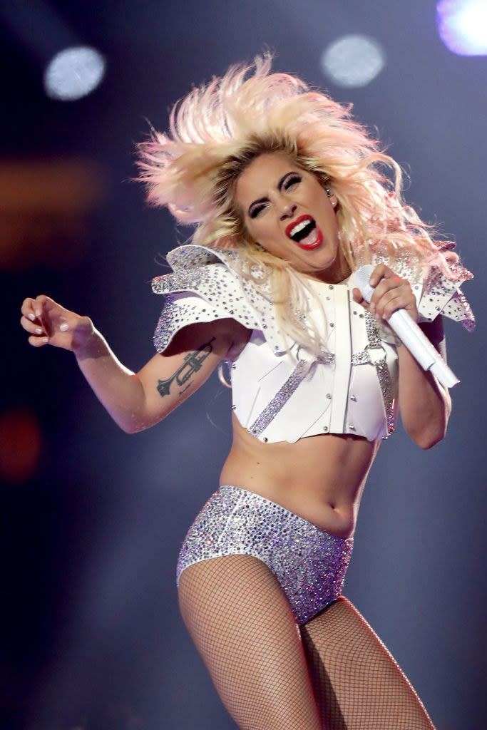 Lady Gaga performing in a two-piece outfit with fishnet stockings