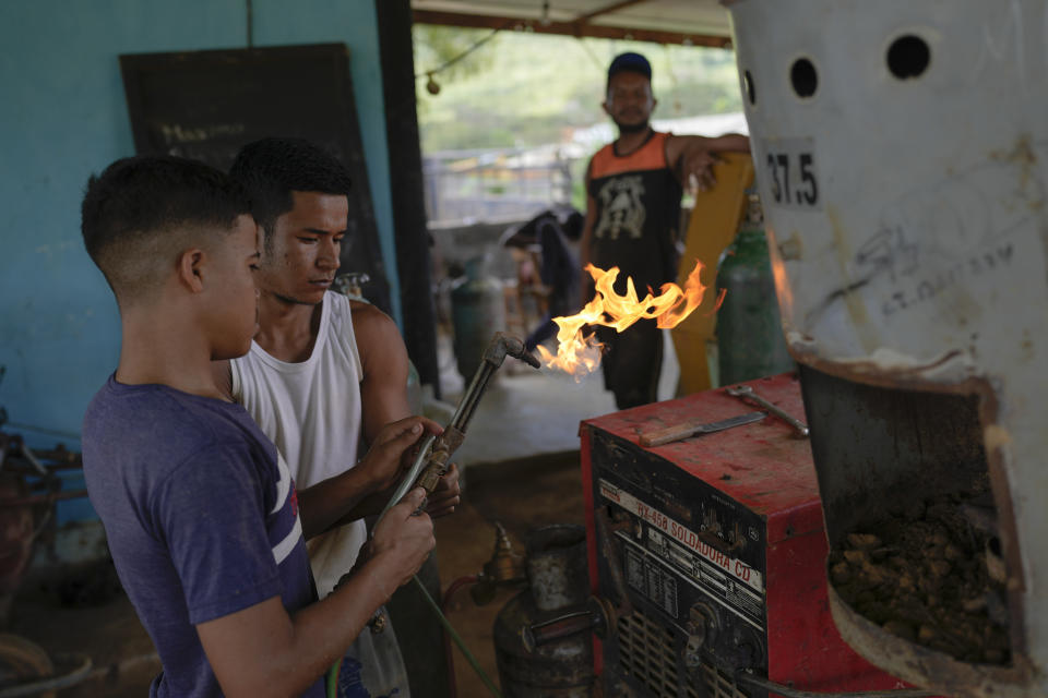 Workers prepare to heat a golden amalgam, to evaporate away the mercury, at a gold mine in El Callao, Bolivar state, Venezuela, Friday, April 28, 2023. (AP Photo/Matias Delacroix)