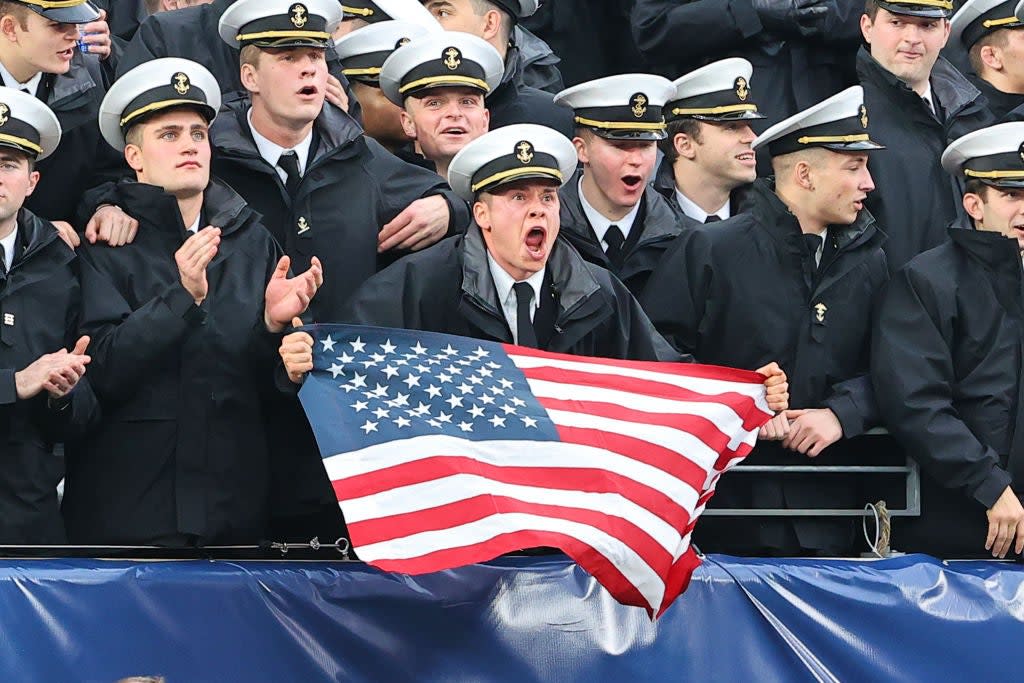 EAST RUTHERFORD, NJ - DECEMBER 11: Navy Midshipmen in the stands holds an Americn Flag yells during the 122nd Army/Navy college football game between the Army Black Knights and the Navy Midshipmen on December 11, 2021 at MetLife Stadium in East Rutherford, NJ. (Photo by Rich Graessle/Icon Sportswire via Getty Images)