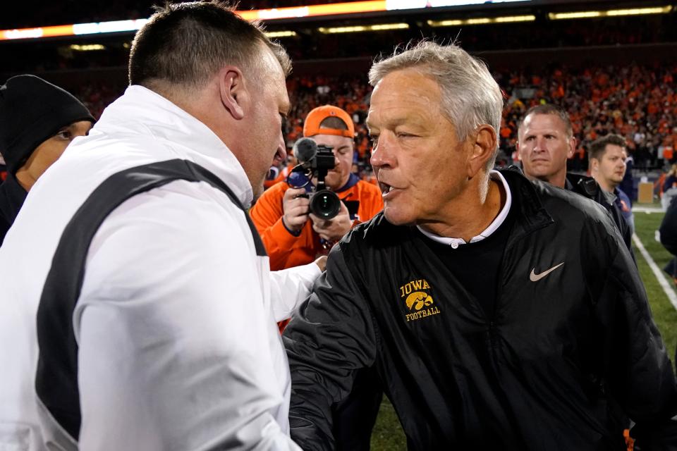 Iowa head coach Kirk Ferentz, right, congratulates Illinois head coach Bret Bielema after Illinois 9-6 win over Iowa after an NCAA college football game Saturday, Oct. 8, 2022, in Champaign, Ill. (AP Photo/Charles Rex Arbogast)