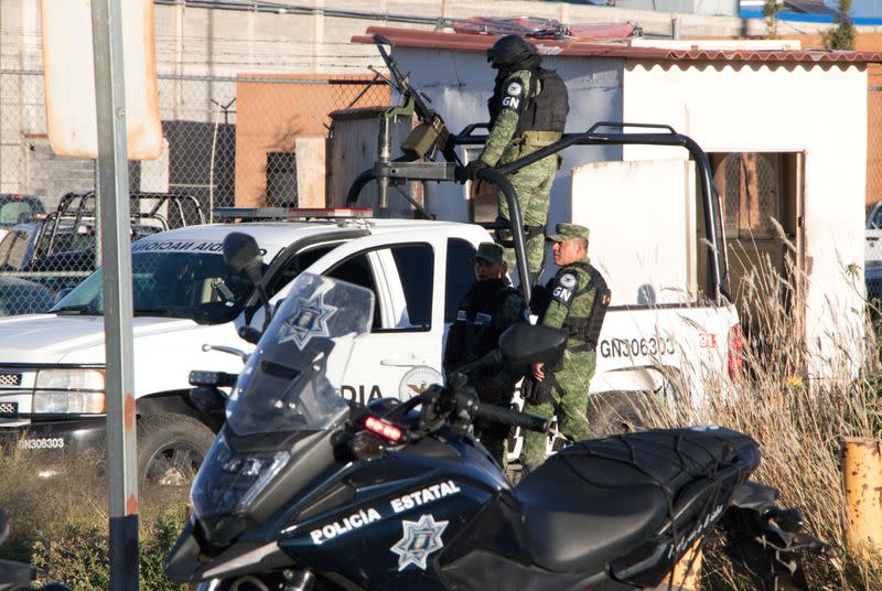 Members of the Mexican National Guard stand atop a vehicle as they keep watch outside the prison after sixteen inmates were killed and five were wounded in a prison fight at the Regional Center for Social Reintegration in the town of Cieneguillas