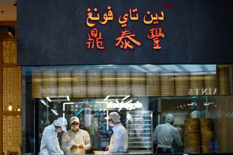 Workers wearing protective face masks prepare food at a restaurant during the reopening of malls, following the outbreak of the coronavirus disease (COVID-19), at Mall of the Emirates in Dubai