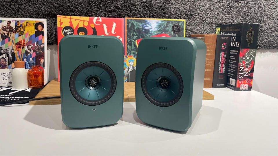 Green KEF LSX II LT on a table in front of books