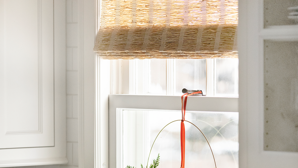 holiday decor kitchen with minimalist hoop adorned with a pair of brass bells and cypress greens