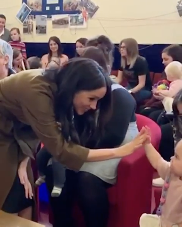 Meghan gets hands-on with a little one at a morning tea. Photo: Instagram/sussexroyal.