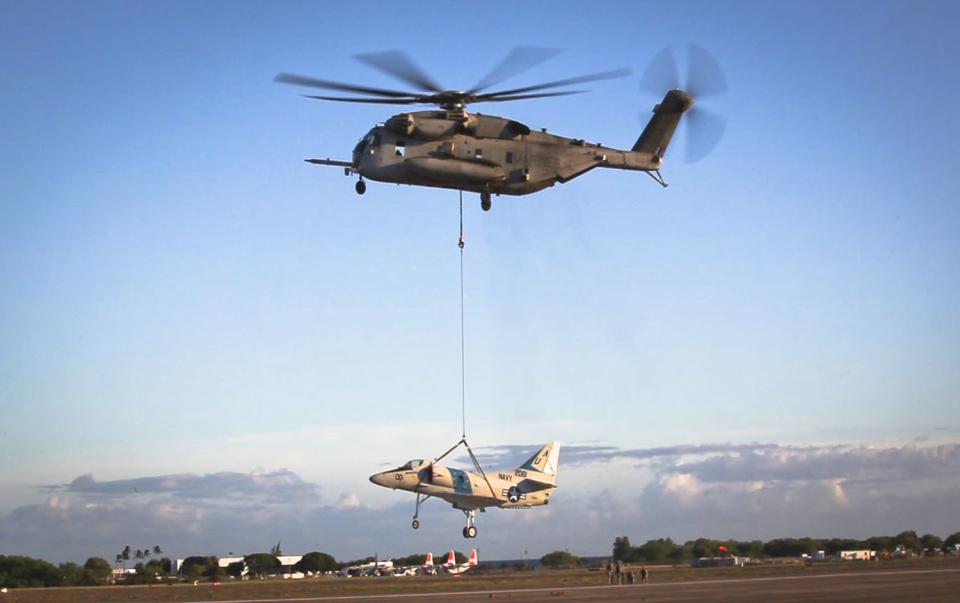 A CH-53E Super Stallion, used by the Marine Heavy Helicopter Squadron 463, carries off an A-4 Jet during a sling load operation aboard Barber's Point Naval Air Station, Marine Corps Base Hawaii on September 23, 2014, in this handout photo provided by the U.S. Marine Corps. The U.S. Coast Guard is searching for two Marine helicopters carrying 12 people after reports that they collided near the island of Oahu in Hawaii, media reports said on January 15, 2016. REUTERS/U.S. Marine Corps/Lance Cpl. Aaron S. Patterson/Handout via Reuters ATTENTION EDITORS - FOR EDITORIAL USE ONLY. NOT FOR SALE FOR MARKETING OR ADVERTISING CAMPAIGNS. THIS IMAGE HAS BEEN SUPPLIED BY A THIRD PARTY. IT IS DISTRIBUTED, EXACTLY AS RECEIVED BY REUTERS, AS A SERVICE TO CLIENTS