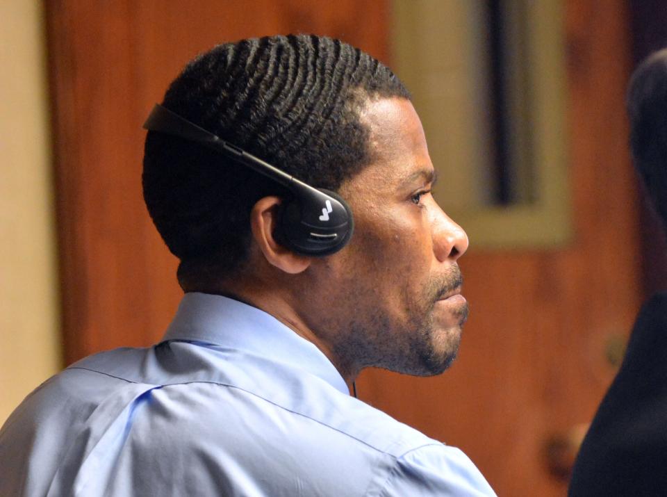 Jean Jacques listens to an interpreter through headsets during the start of his original trial at New London Superior Court in 2016.