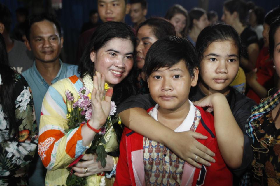 A prominent leader of Cambodia's land rights activist Tep Vanny, second from left, gestures upon the arrival at her home in Boeung Kak, in Phnom Penh, Cambodia, Monday, Aug. 20, 2018. A prominent leader of Cambodia's land rights movement and three women activists who were sent to prison with her were freed Monday under a royal pardon. (AP Photo/Heng Sinith)