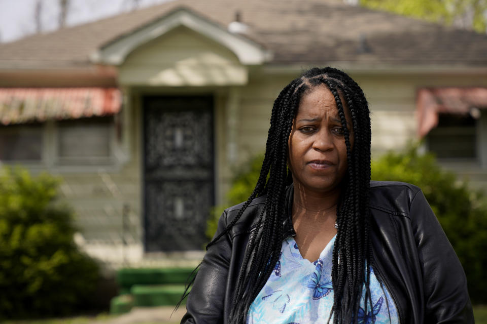 Karen Pitchford-Knox stands in front of her home Monday, April 19, 2021, in Kansas City, Kan. Pitchford-Knox found out from a state senator that her home was put up for sale by Wyandotte County in January when she fell behind on her property tax payments after loosing her job during the pandemic. (AP Photo/Charlie Riedel)