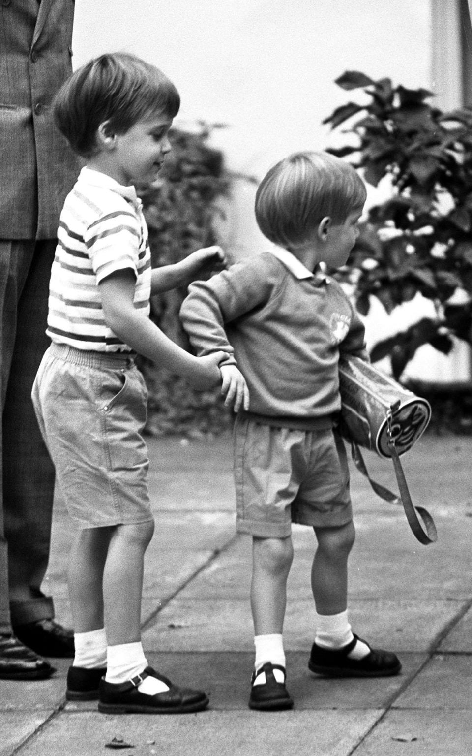 A three year old Prince Harry receives a helping hand from his older brother Prince William on his first day at kindergarten in Chepstow Villas in 1987 (PA)