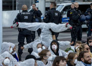 Activist perform as they block the main entrance of the fairground in Frankfurt, Germany, Sunday, Sept. 15, 2019. They protest against the government's transport policy on occasion of the IIA Auto Show taking place. (AP Photo/Michael Probst)