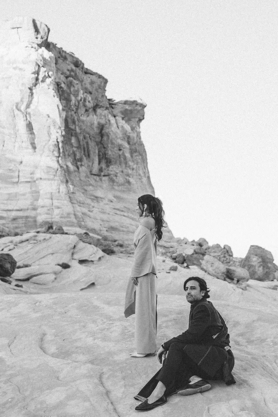 a man and woman sitting on a snowy hill