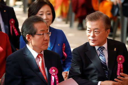 Moon Jae-in (R), presidential candidate of the Democratic Party of Korea, talks with Hong Joon-pyo, presidential candidate of the Liberty Korea Party, during a ceremony celebrating the birthday of Buddha at Jogye temple in Seoul, South Korea, May 3, 2017. REUTERS/Kim Hong-Ji