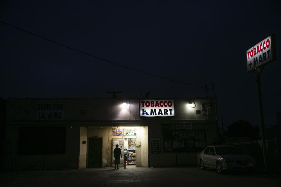 A man walks into a grocery store Tuesday, June 30, 2020, in the Watts neighborhood of Los Angeles. There were no fires this time in Watts. There was no looting, no shooting and no National Guard troops patrolling the streets. When protesters around the country began demanding racial justice over the Minneapolis police killing of George Floyd, there may have been mentions of Watts and faint echoes of the riots that broke out in the Los Angeles neighborhood 55 years ago. But they didn't happen there. (AP Photo/Jae C. Hong)