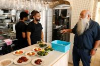 Le cuisinier israélien Uri Jeremias discutant avec des employés dans son restaurant de fruits de mer à Acre, le 2 mai 2022 (AFP/JACK GUEZ)
