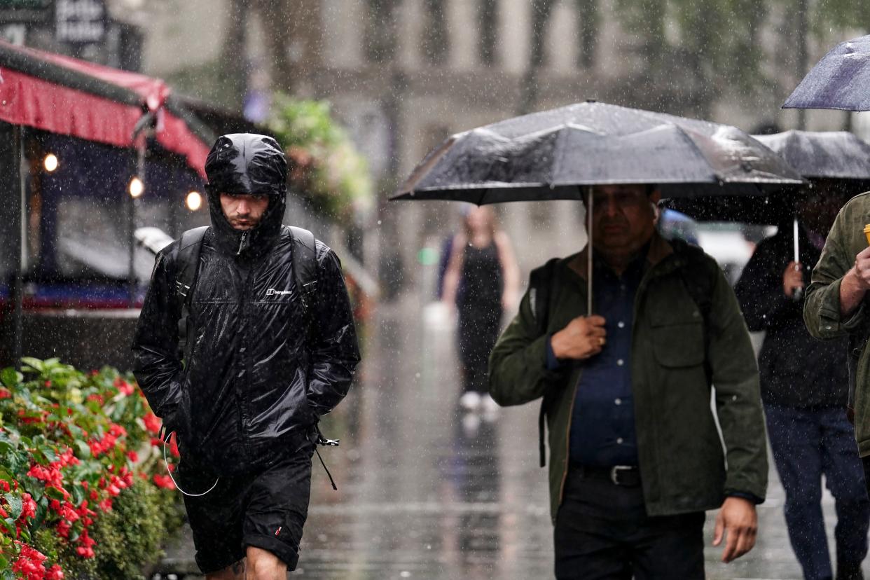 People caught during a heavy downpour of rain in Leicester Square, London, Wednesday 2 August (PA)