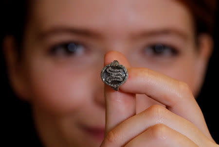 FILE PHOTO: A model holds a diamond ring bearing the initials MA for Marie Antoinette and containing a lock of her hair during a press preview ahead of the upcoming auction "Royal jewels from the Bourbon Parma Family" at Sotheby's in Geneva, Switzerland November 7, 2018. REUTERS/Denis Balibouse/File Photo