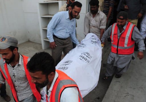 Pakistani volunteers carry the body of a policeman to a hospital following an attack by gunmen in Karachi on Thursday. Senior police official Rao Anwar said he was the target and claimed to have been threatened for a month by "unknown terrorists"